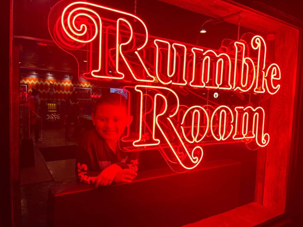 A Maggie's Rumble Room neon sign hangs in the bar's front window
